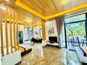 HeniSi 2 Hotel Măng Đen في Kon Von Kla: غرفة نوم مع سرير وغرفة معيشة مع طاولة