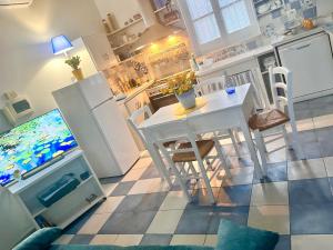 a kitchen with a white table and a kitchen with a video game at La casa gialla in Campobasso