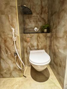a bathroom with a toilet and a shower at Lux Living Hotel in Bengaluru
