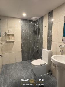 a bathroom with a toilet and a shower and a sink at سوات للشقق المخدومة 5 in Al Khobar +81 photos