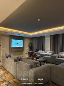 a large living room with couches and a flat screen tv at سوات للشقق المخدومة 5 in Al Khobar