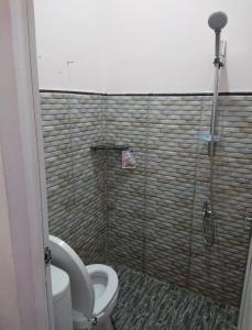 a bathroom with a toilet and a shower at Astiti Ayu Kost Bagirati 1 in Tjakranegara