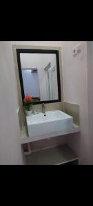 a bathroom with a white sink and a mirror at Astiti Ayu Kost Bagirati 1 in Tjakranegara