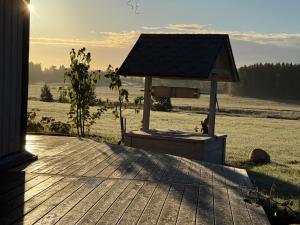 a wooden deck with a barbecue grill in a field at New log cabin near Tartu in Nõo