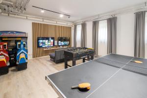 a room with a ping pong table and a video game at Hotel Nummerhof in Erding