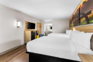 a hotel room with two beds and a tv at Days Inn by Wyndham Enterprise in Enterprise