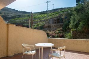 a table and chairs on a patio with a view of a hill at Hotel Cala Joncols in Roses