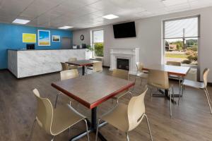 a meeting room with tables and chairs and a fireplace at Days Inn by Wyndham Cambridge in Cambridge