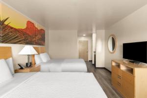 a hotel room with a bed and a flat screen tv at Days Inn by Wyndham Chino Valley in Chino Valley