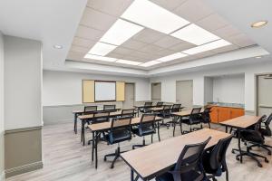 a classroom with desks and chairs in a classroom at Days Inn & Suites by Wyndham Cedar Rapids in Cedar Rapids +35 photos