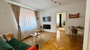 a living room with a green couch and a table at Maple Lodge in Braşov
