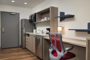 a kitchen with a red chair in a room at Home2 Suites By Hilton Cleveland, Tn in Cleveland