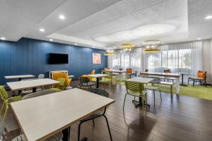 a dining room with tables and chairs and a tv at Spark by Hilton Green Bay in Green Bay