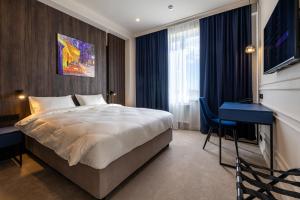 a hotel room with a bed and a desk at Art Hotel in Chişinău +92 photos