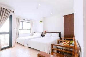 a hotel room with two beds and a window at Lotus Rock Hotel Đà Nẵng in Danang