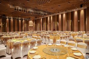 a large banquet hall with tables and white chairs at The Light Arena Ocean Tower in Cam Ranh International Airport