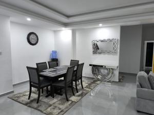 a dining room with a table and chairs and a clock at Kathy's place in Nyali in Mombasa