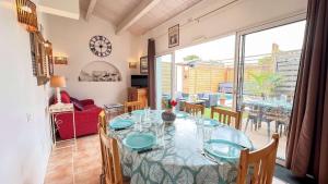 a dining room with a table and a large window at Charmante location à proximité de la plage et des commerces in Rivedoux-Plage +6 photos