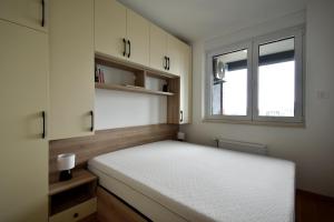 a small bedroom with a bed and a window at Panorama Studio in Novi Sad