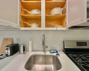 a kitchen counter with a sink and cups and dishes at The Marquee House in New York +14 photos