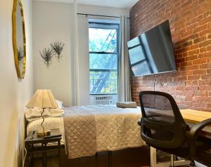 a bedroom with a bed and a brick wall at The Marquee House in New York