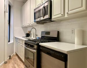 a kitchen with a stove and a microwave at The Marquee House in New York