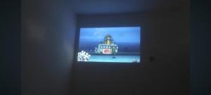 a television screen with a picture of a house on it at Astiti Ayu Kost Bagirati 2 in Tjakranegara