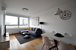 a living room with a blue couch and a table at Panorama Studio in Novi Sad