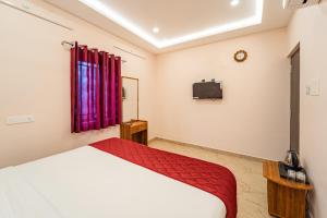 una camera da letto con un letto e una TV a parete di VSA Residency Near Eden Beach a Pūrnānkuppam