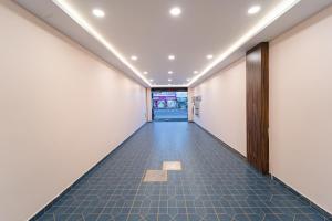 un corridoio vuoto di un edificio per uffici con pareti bianche di VSA Residency Near Eden Beach a Pūrnānkuppam