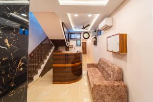 una sala d'attesa con divano e orologio di VSA Residency Near Eden Beach a Pūrnānkuppam Altre 30 foto