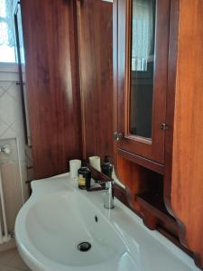 a bathroom with a white sink and a wooden cabinet at Golden House Venice Yellow - Mirano in Mirano