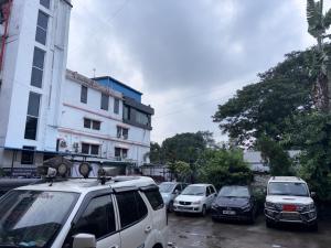 una fila di auto parcheggiate in una strada della città di Hotel shree nayak purnia a Pūrnia