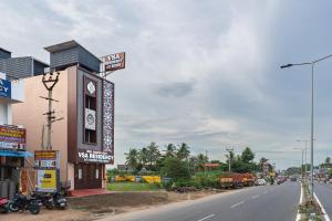 a building with a clock tower on the side of a street at VSA Residency in Pūrnānkuppam
