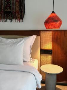 a bedroom with a bed with a table next to it at The Clifton Canggu in Canggu +26 photos