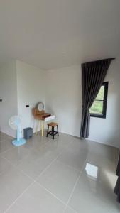 a living room with a table and a window at สวนไร่รุ่งอรุณ Suan Rai Rungarun in Ban Na Pa Paek