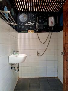 a bathroom with a sink and a shower at B&R Hostel in Puerto Princesa City