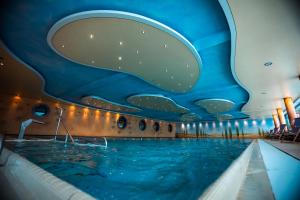 a swimming pool in a hotel with a blue ceiling at Hotel Hochsauerland 2010 in Willingen