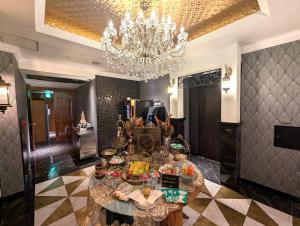 a dining room with a chandelier and a table with food at Hotel PALM GATE in Fukuoka