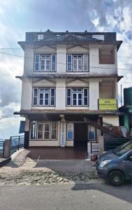 a house with a car parked in front of it at Hotel Rainbow Regency Ravangla South Sikkim in Ravangla