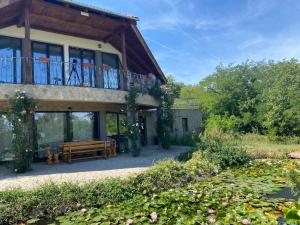 a house with a deck and a bench and a pond at Szelek Palotája in Écs
