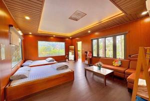 a bedroom with a large bed and a couch at Henisi Homestay Măng Đen in Kon Von Kla