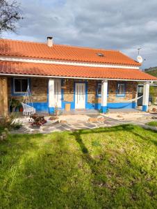 a house with an orange roof and a yard at Casinha das Estrelas in Cerejeira