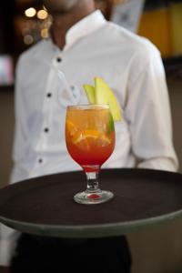 Ein Getränk steht auf einem Tisch, im Hintergrund ist eine Person zu sehen. in der Unterkunft Sunny Days El Palacio Resort & Spa in Hurghada
