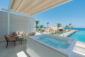 a hot tub on the balcony of a house overlooking the ocean at Sunny Days El Palacio Resort & Spa in Hurghada