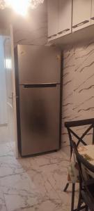 a stainless steel refrigerator in a kitchen next to a wall at Myhouse in Ariana +11 photos