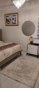 a bedroom with a bed and a table and a chandelier at Myhouse in Ariana