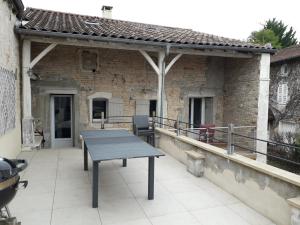 a patio with a table and chairs on a building at Maison bourguignonne in Lugny