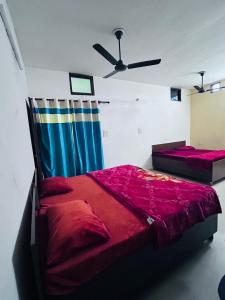 a bedroom with two beds and a ceiling fan at Delight Inn Guest House & PG in Lālewāl