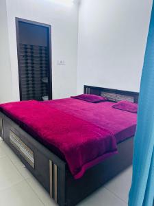 a bedroom with a large bed with a red comforter at Delight Inn Guest House & PG in Lālewāl